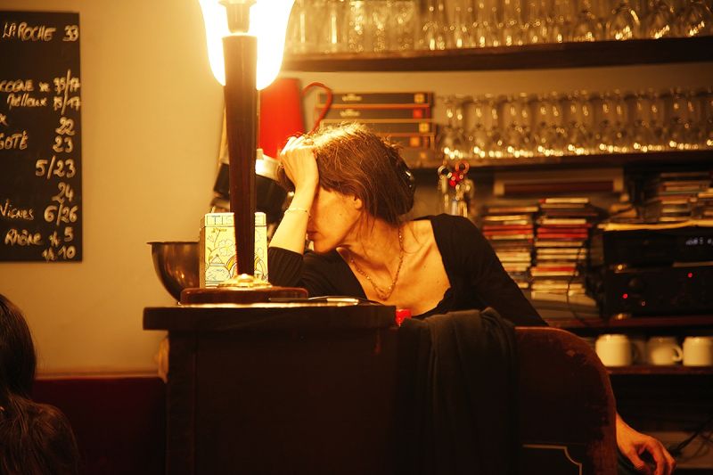 women in cafe with hand on face