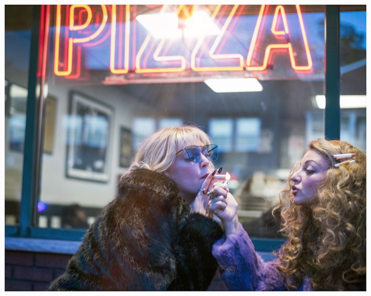 women in window of pizza parlor