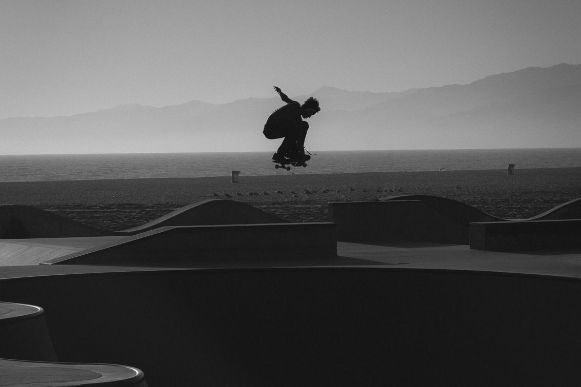 black and white photo of skateboarder in the ari
