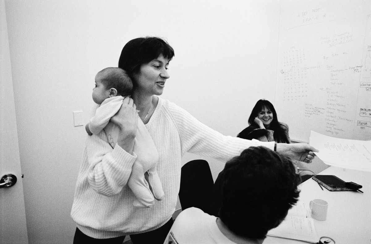 The Newton War Room at Apple Computer. Cupertino, California, 1993. Apple programmer Sarah Clark delivers a message to the Newton War Room.  Sarah kept her baby with her at work, almost never leaving the building for two years as the team rushed to finish the software. She pulled curtains over the glass of her office so colleagues knew when it was naptime or if she was breastfeeding. Her dedication was typical of Apple employees and management was generally grateful. Flexible hours and other worker-friendly modifications were adopted, and John Sculley showed leadership by appointing women to positions of power on the Newton team, almost unheard of in Silicon Valley.
